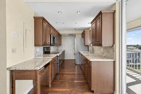 a kitchen with stainless steel appliances granite countertop a sink stove and refrigerator