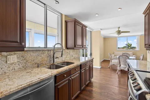 a kitchen with stainless steel appliances granite countertop a sink and wooden cabinets