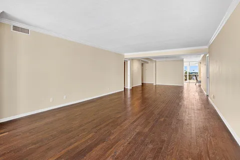 a view of an empty room with wooden floor