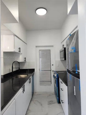 a kitchen with stainless steel appliances granite countertop a refrigerator and a stove