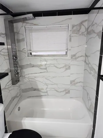 a bathroom with a toilet mirror and sink