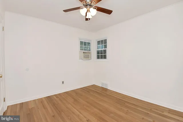 an empty room with a window and a ceiling fan