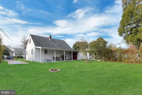 a view of a house with a big yard and large trees