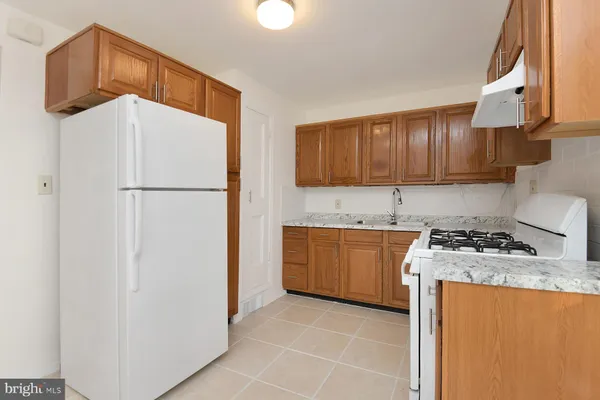 a kitchen with granite countertop a refrigerator a stove a sink a washer and dryer