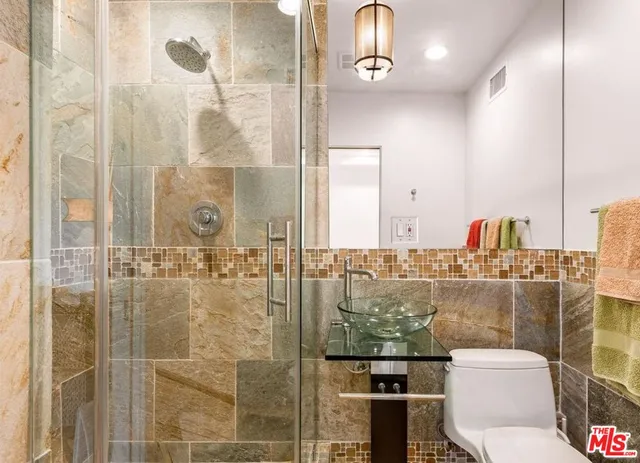 a bathroom with a toilet shower and a sink