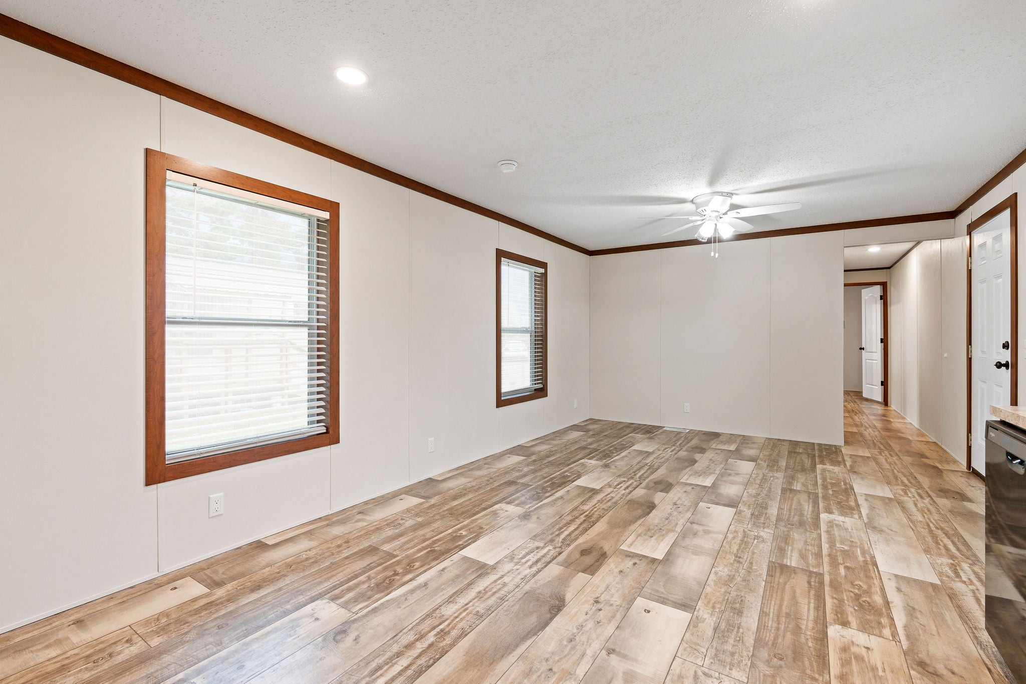 110 Van Sant Road, Unit 15 Kalispell, MT 59901 - Photo 13 of 22 Open living space highlighting the decorative ceiling fan and the windows' dark wood trim