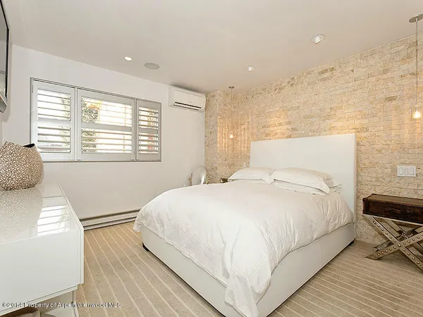 a large bed sitting in a bedroom next to a window