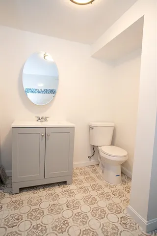 a bathroom with a toilet a sink and a mirror