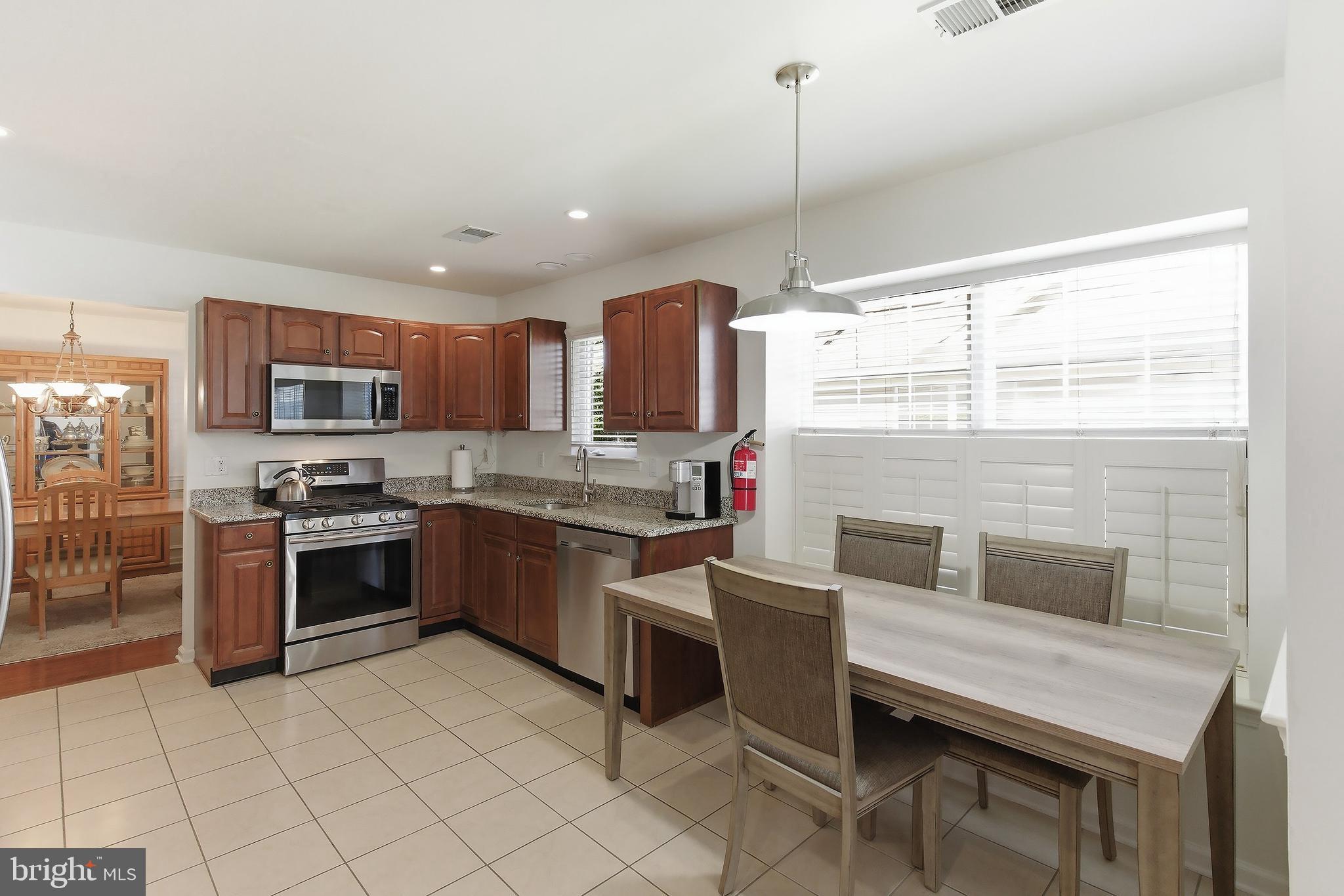 7 Ivy Hill Road Lakewood, NJ 08701 - Photo 17 of 51 a kitchen with stainless steel appliances granite countertop a stove top oven a sink dishwasher a dining table and chairs