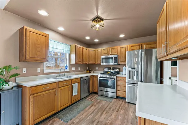 a kitchen with stainless steel appliances granite countertop a sink refrigerator and cabinets