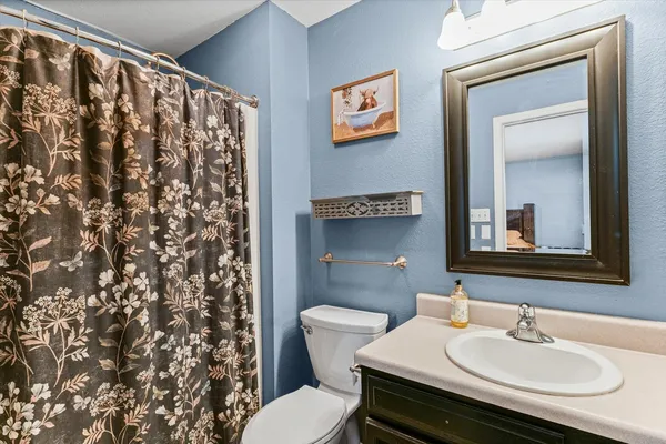 a bathroom with a sink toilet and a mirror