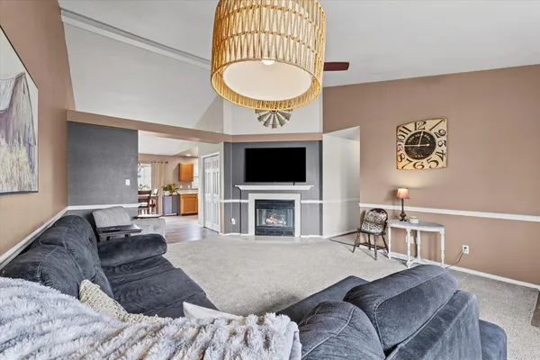 a living room with furniture a chandelier and a flat screen tv