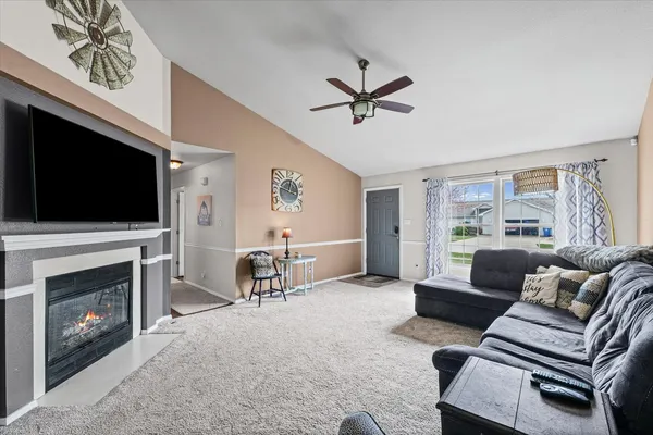 a living room with furniture a flat screen tv and a fireplace