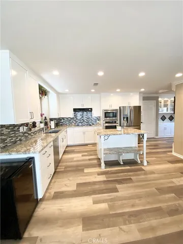 a view of kitchen with granite countertop lots of counter top and stainless steel appliances