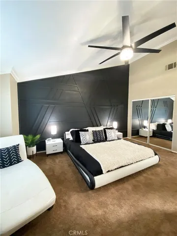 a large bed sitting in a room next to a lamp and a chandelier