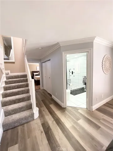a view of a hallway with wooden floor and cabinet