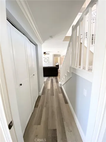 a view of a hallway with wooden floor and staircase