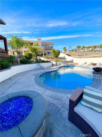 a view of a swimming pool with a lawn chairs under an umbrella