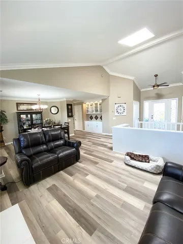 a large living room with couches and a dining table with wooden floor