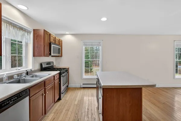 a kitchen with a sink wooden floor and a window