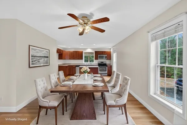 a dining room with furniture a floor to ceiling window and wooden floor