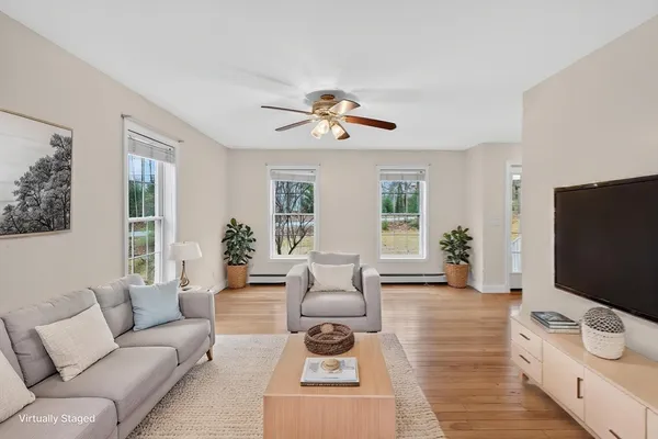 a living room with furniture a flat screen tv and a chandelier