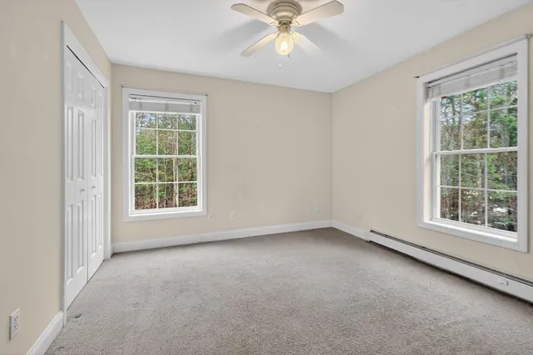 an empty room with a window and a fan