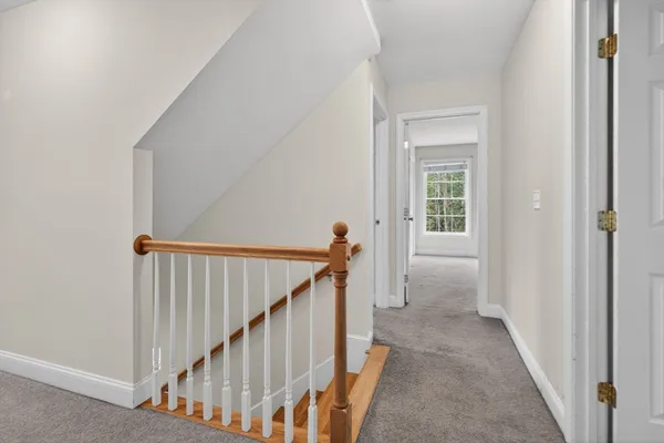 a view of a hallway with wooden floor and stairs