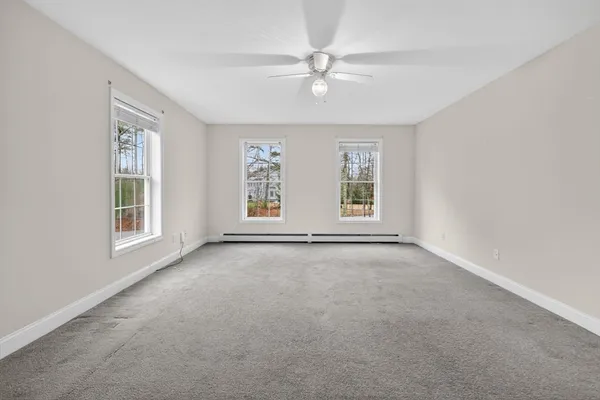 an empty room with windows and fan