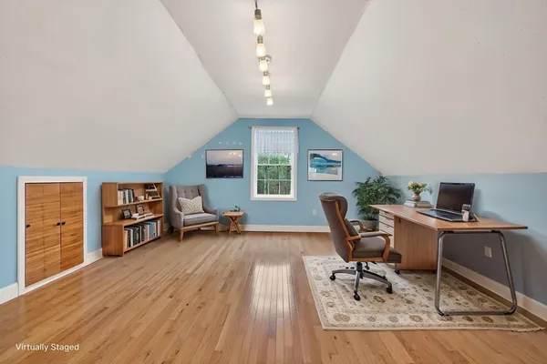 a workspace with furniture wooden floor and a window