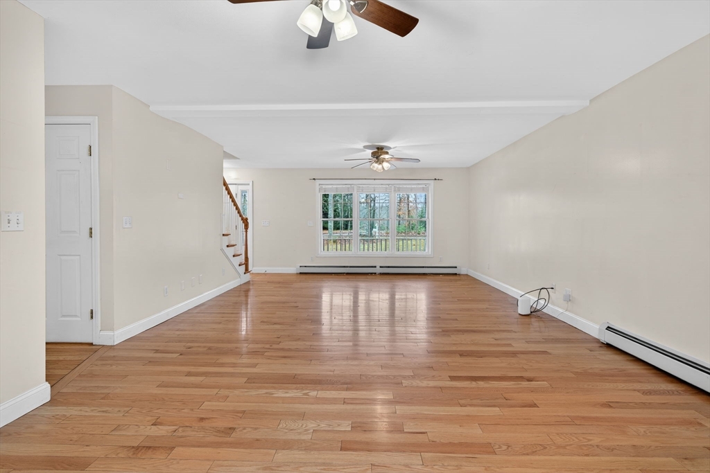 15 Scribner Road Fremont, NH 03044 - Photo 8 of 42 an empty room with wooden floor fan and windows