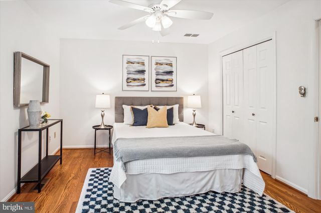 a bedroom with a bed rug and wooden floor