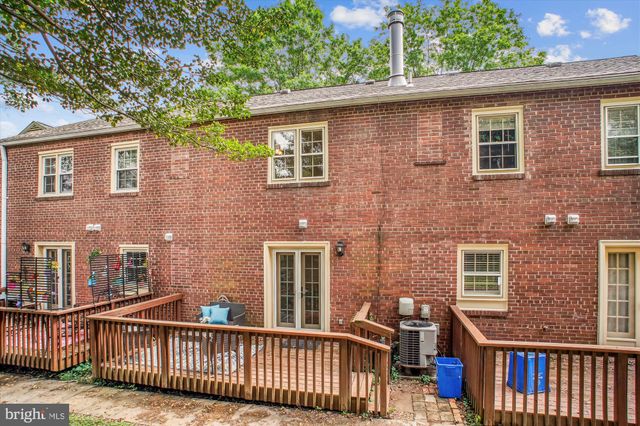 a view of a brick house with large windows and a large tree