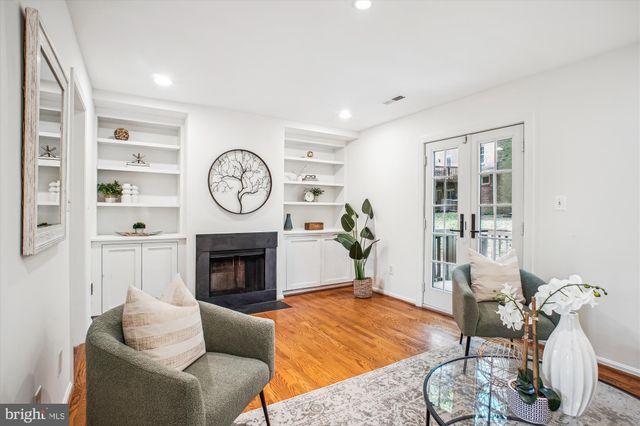 a living room with furniture a clock and a fireplace