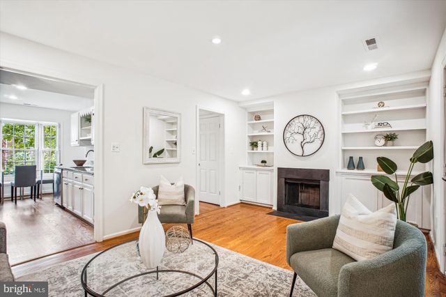 a living room with furniture a clock and a fireplace