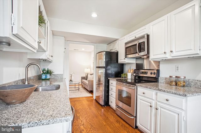 a kitchen with stainless steel appliances granite countertop a stove a sink dishwasher and a refrigerator