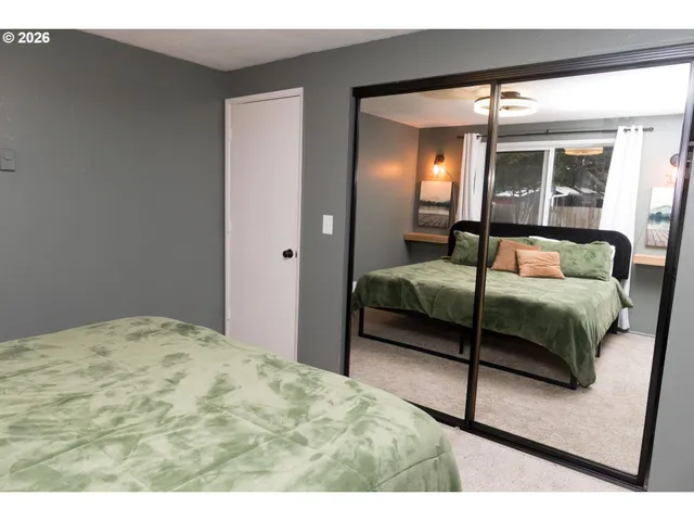 a bedroom with a bed and a large mirror