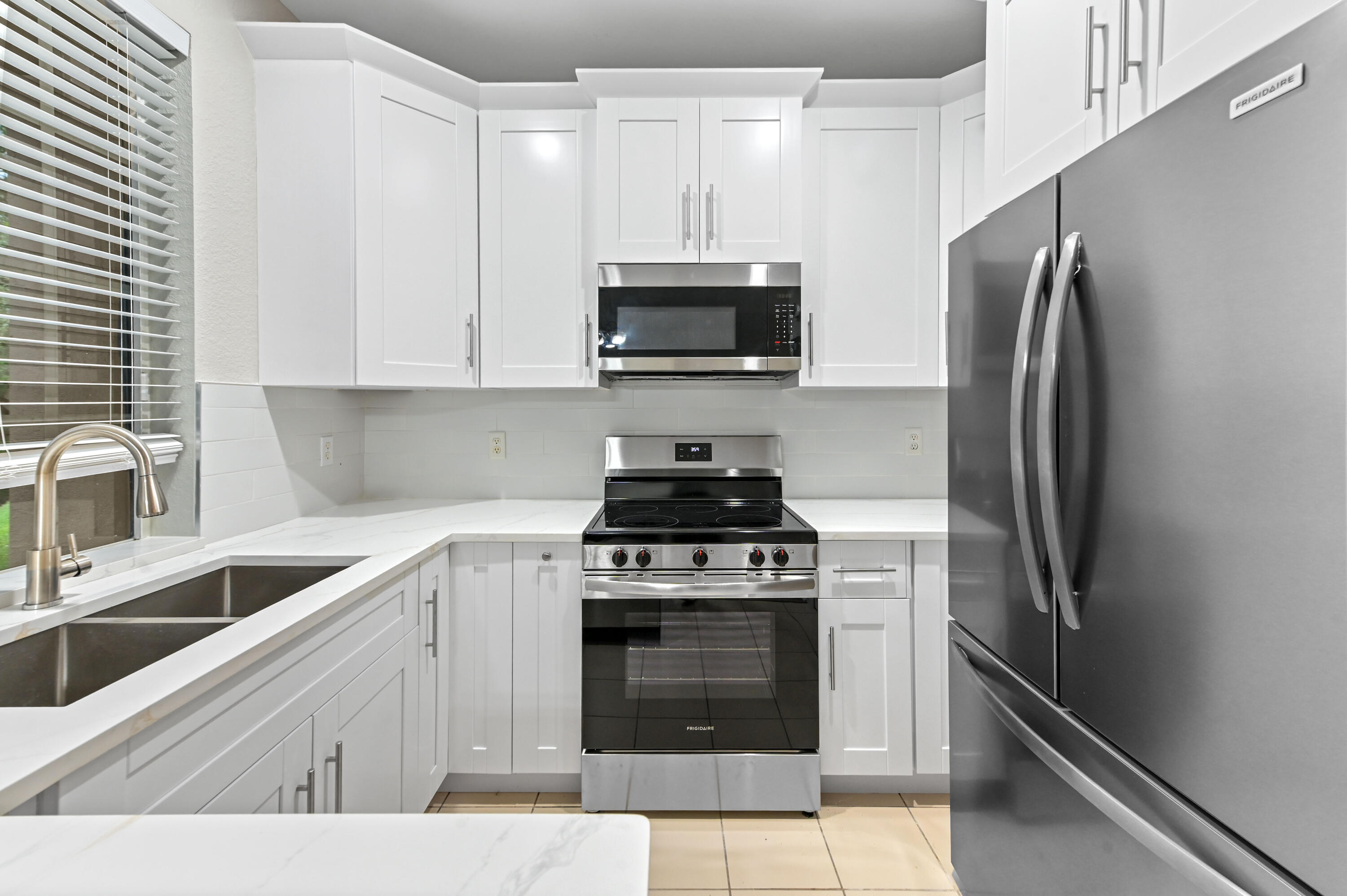 975 Tortuga Drive Riviera Beach, FL 33404 - Photo 12 of 29 a kitchen with a stove and a refrigerator