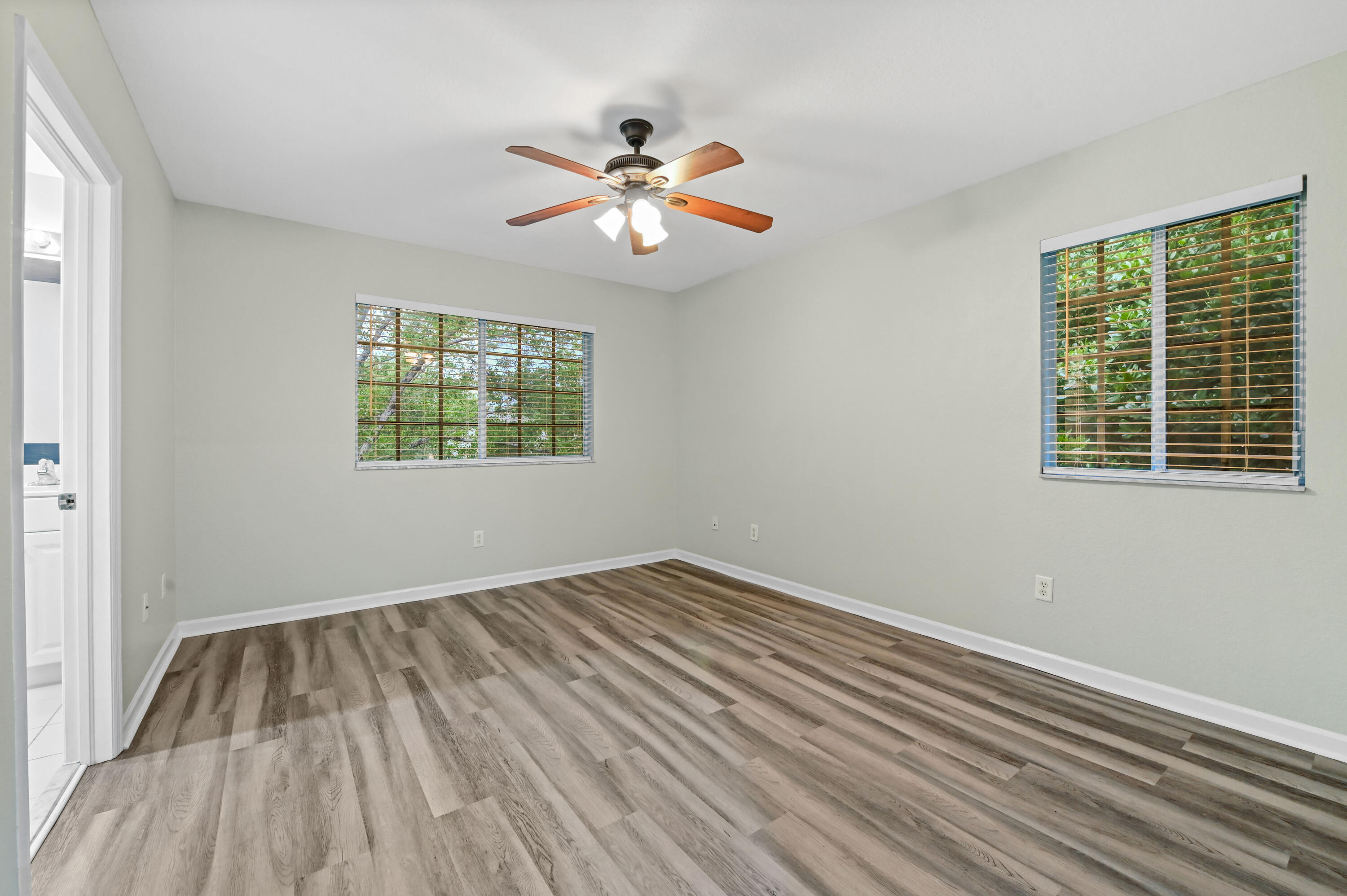 975 Tortuga Drive Riviera Beach, FL 33404 - Photo 21 of 29 a view of empty room with wooden floor and fan