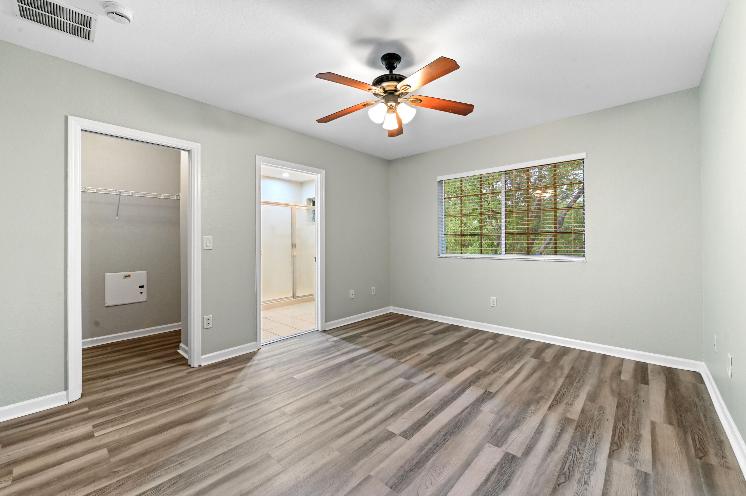 975 Tortuga Drive Riviera Beach, FL 33404 - Photo 22 of 29 an empty room with wooden floor fan and windows