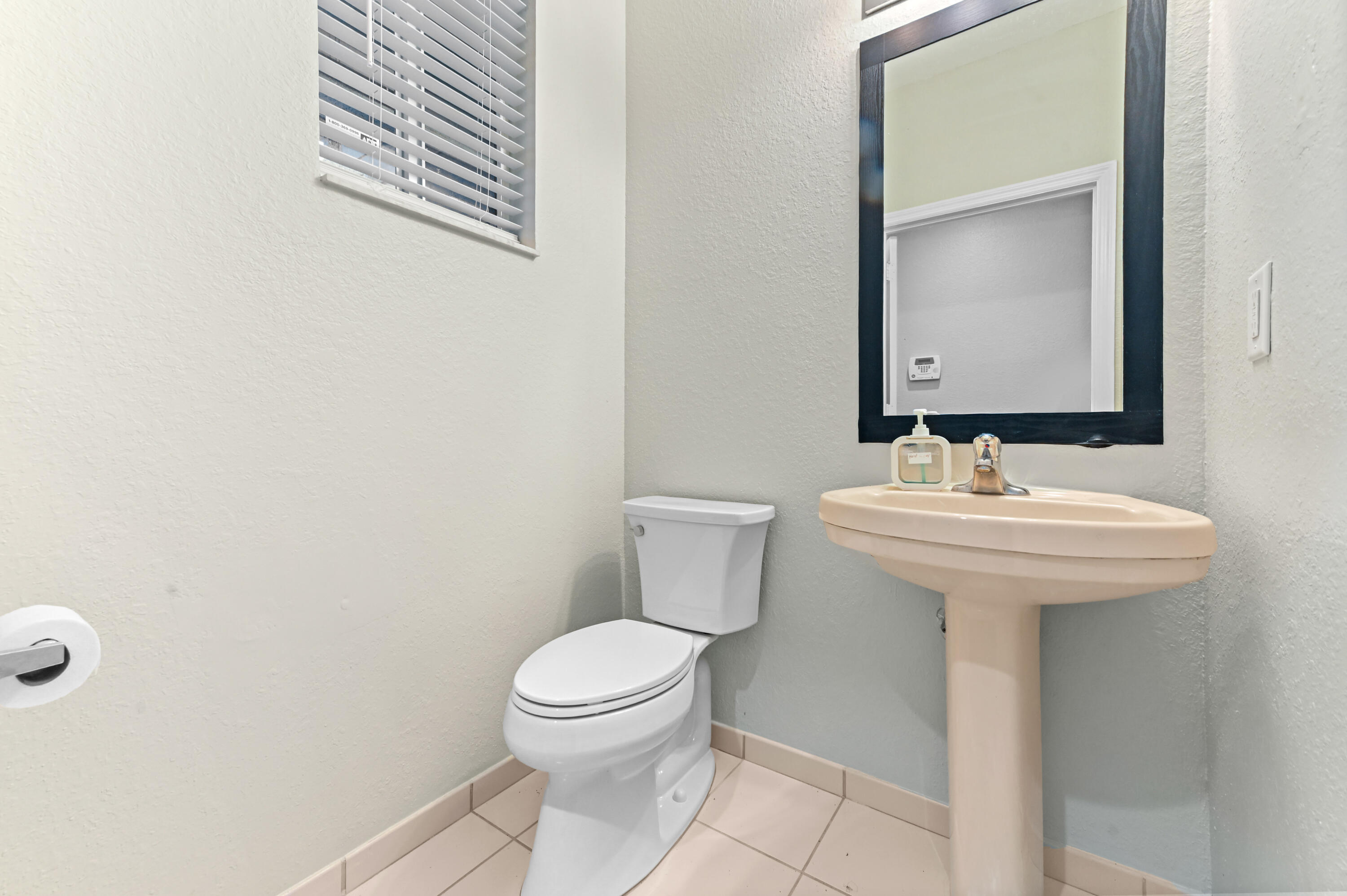 975 Tortuga Drive Riviera Beach, FL 33404 - Photo 4 of 29 a bathroom with a sink a toilet and mirror