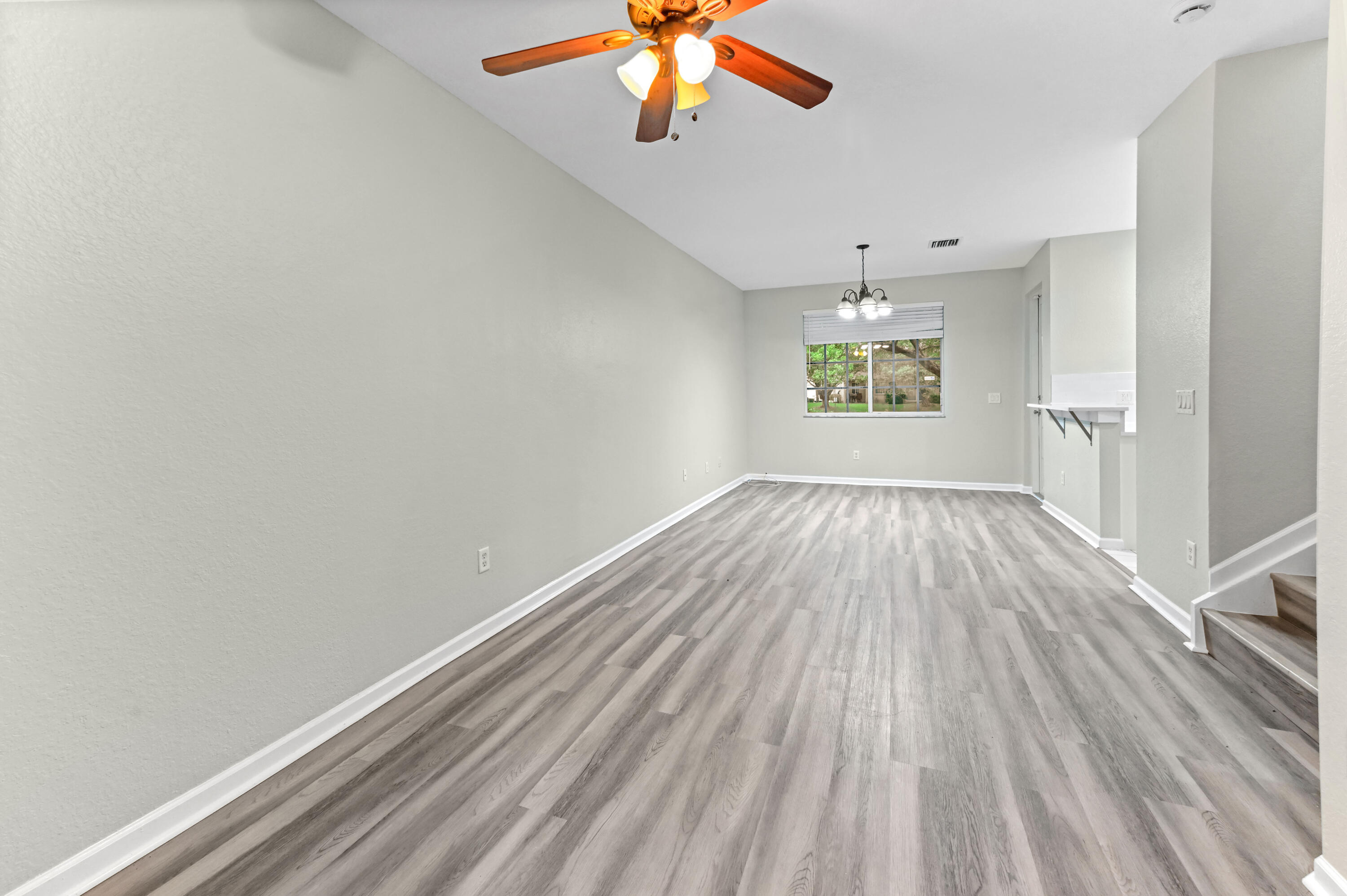 975 Tortuga Drive Riviera Beach, FL 33404 - Photo 5 of 29 wooden floor in an empty room with a window