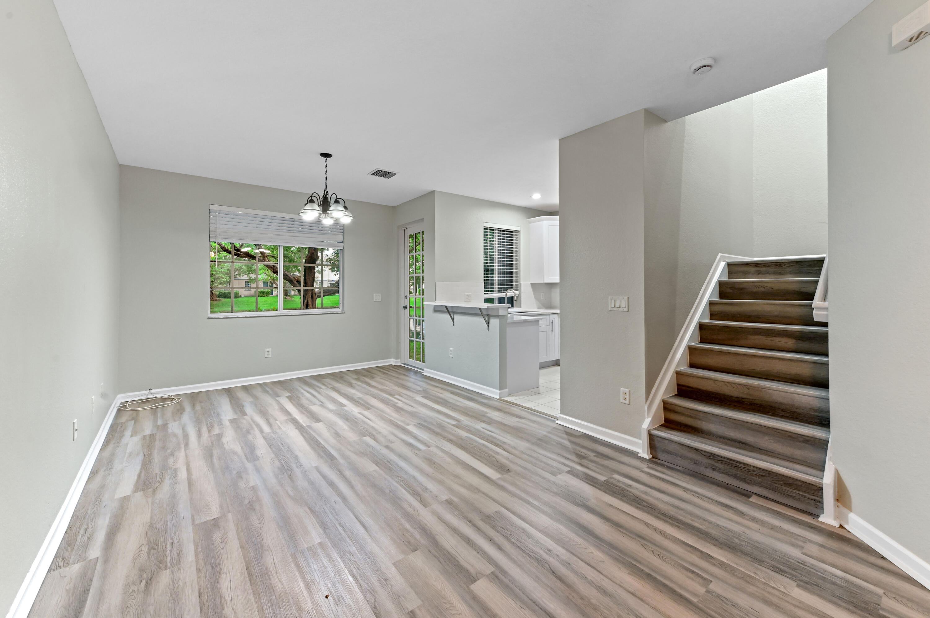 975 Tortuga Drive Riviera Beach, FL 33404 - Photo 6 of 29 a view of a kitchen with wooden floor electronic appliances and stairs
