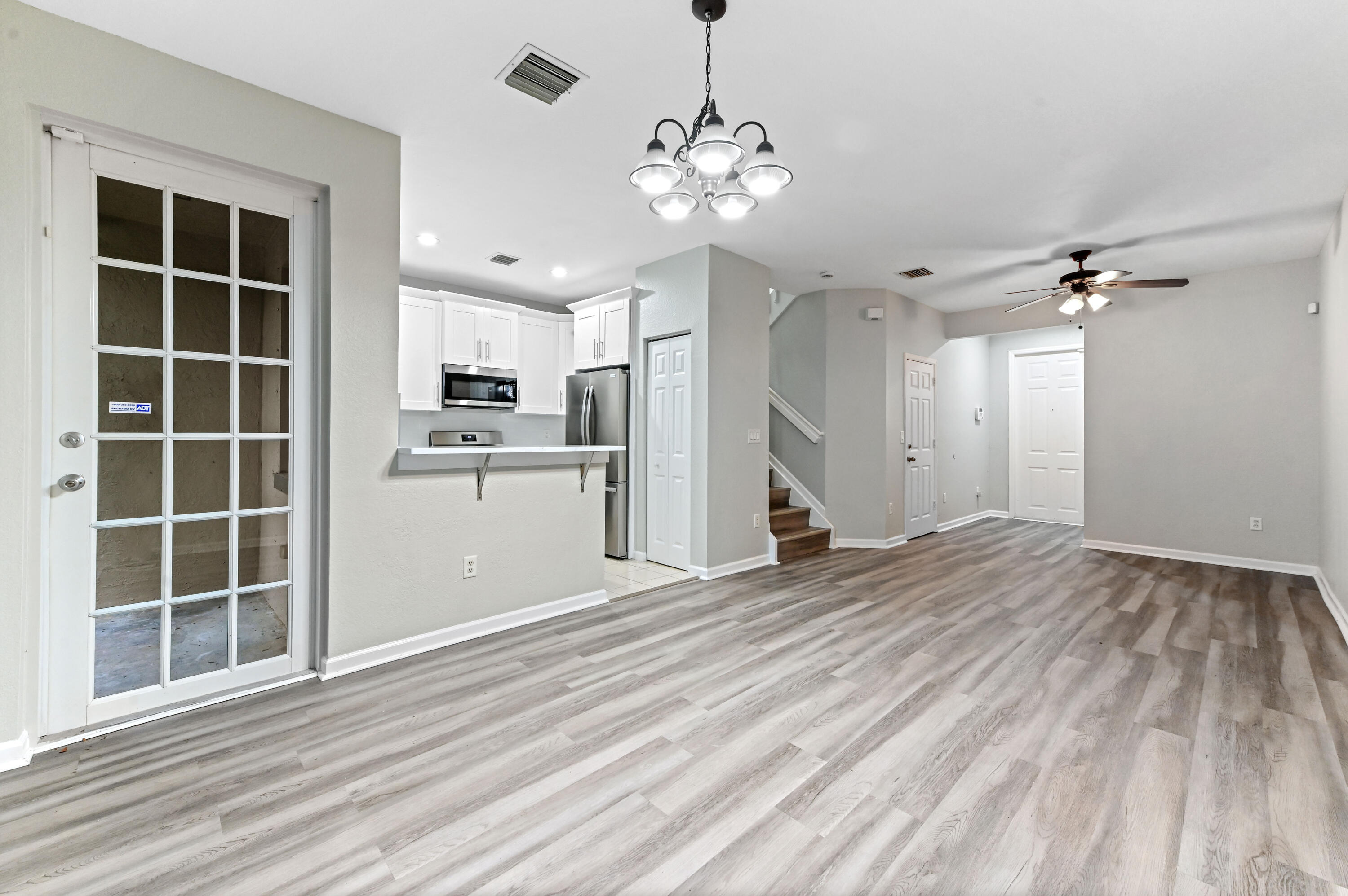 975 Tortuga Drive Riviera Beach, FL 33404 - Photo 8 of 29 a view of a kitchen with wooden floor and a ceiling fan