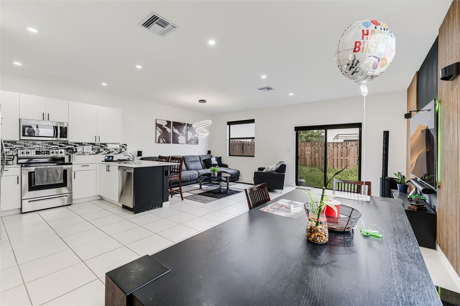 13073 Southwest 286th Street Homestead, FL 33033 - Photo 22 of 53 a kitchen with a sink dishwasher a stove and a dining table with wooden floor