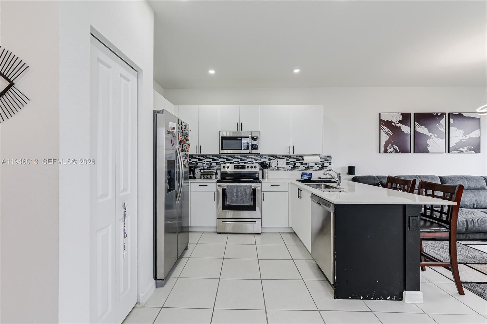 13073 Southwest 286th Street Homestead, FL 33033 - Photo 23 of 53 a kitchen with stainless steel appliances a stove a sink and a refrigerator