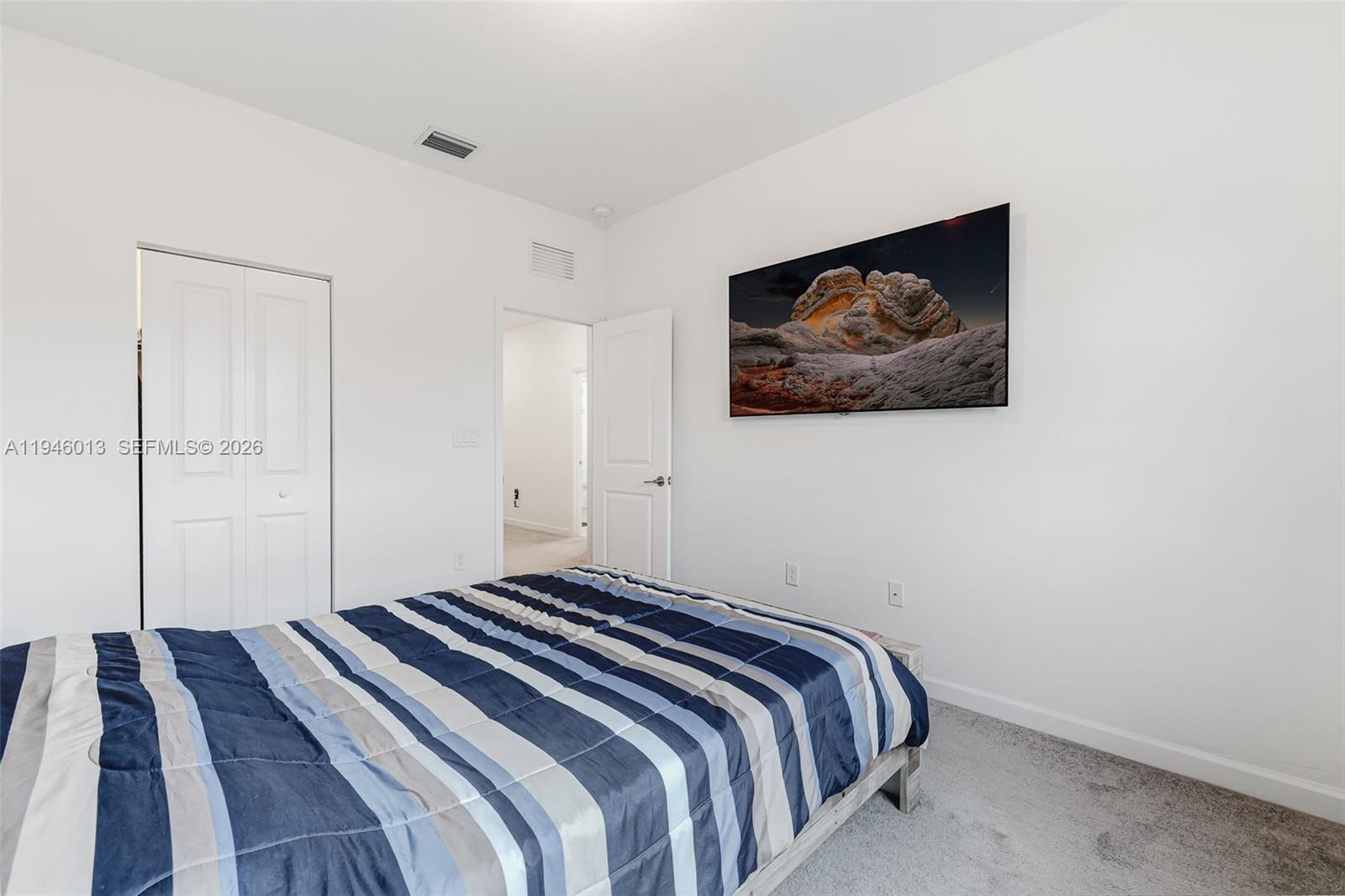 13073 Southwest 286th Street Homestead, FL 33033 - Photo 37 of 53 a bedroom with a bed and a painting on the wall