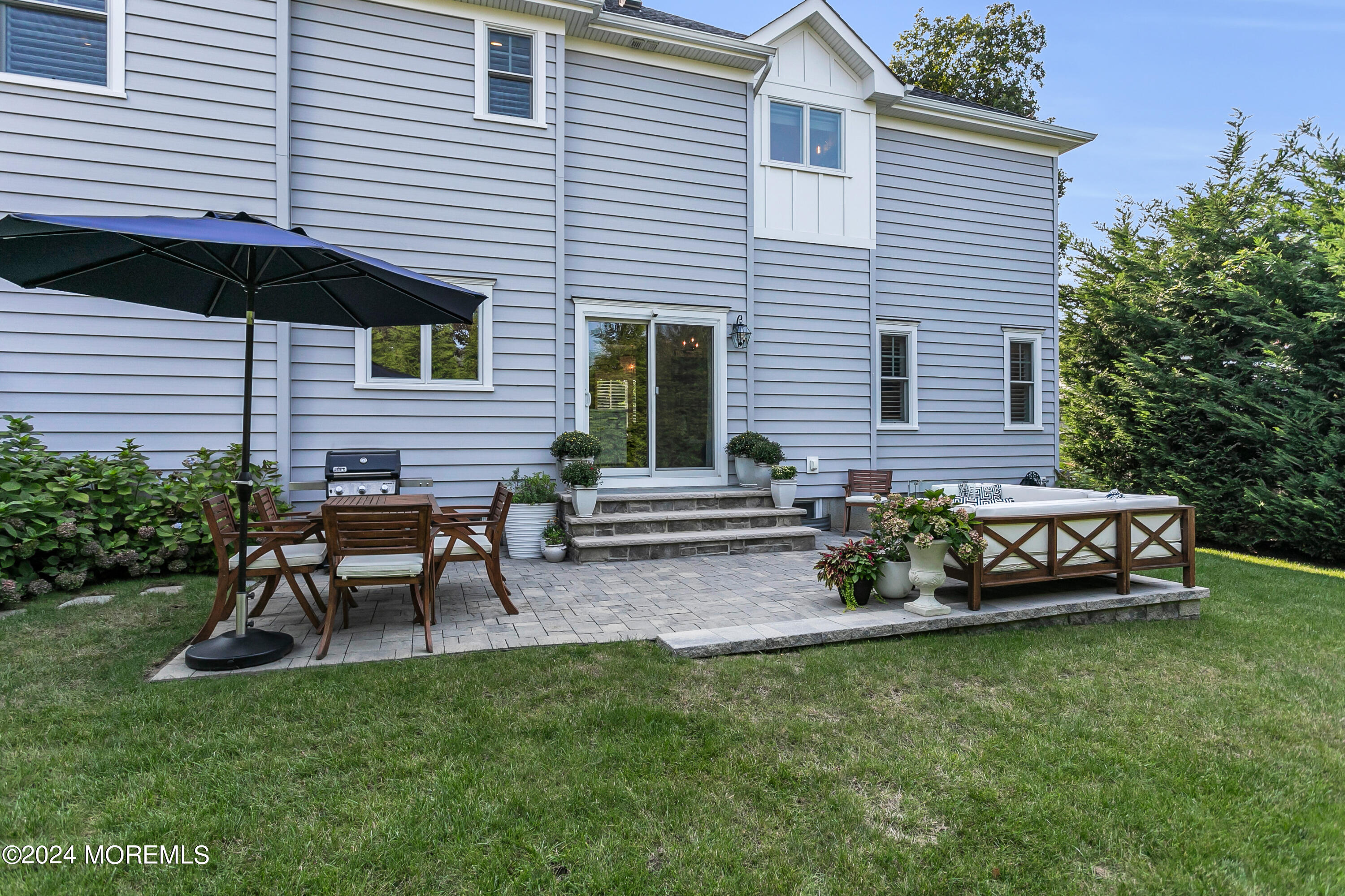 27 Center Street Rumson, NJ 07760 - Photo 48 of 57 a backyard of a house with table and chairs