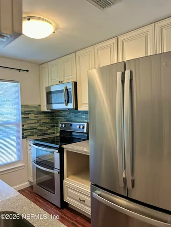 a kitchen with granite countertop a refrigerator and a sink