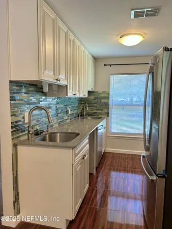 a kitchen with a sink a counter top space cabinets and a window